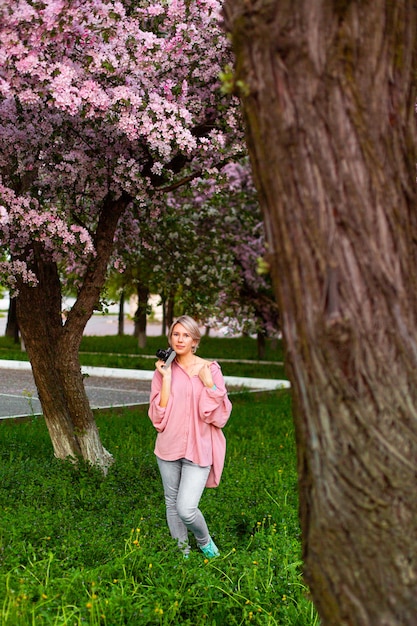 Belle jeune femme dans le jardin des cerisiers en fleurs