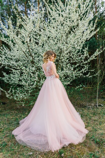 Belle jeune femme dans un jardin fleuri. La mariée.