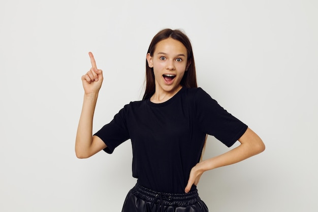 Belle jeune femme dans un t-shirt noir geste de la main amusant fond isolé