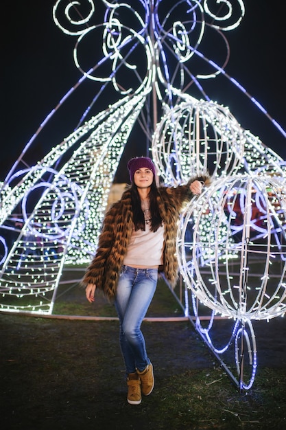 La belle jeune femme debout près de la foire de Noël