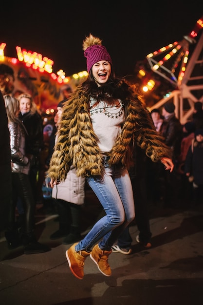 La belle jeune femme debout près de la foire de Noël