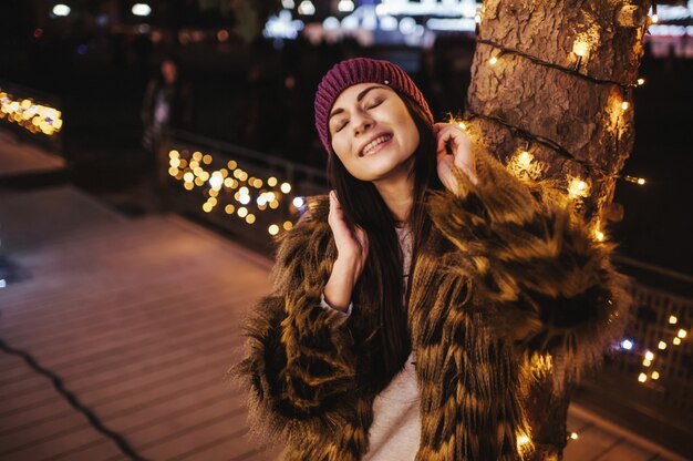 La belle jeune femme debout près de la foire de Noël