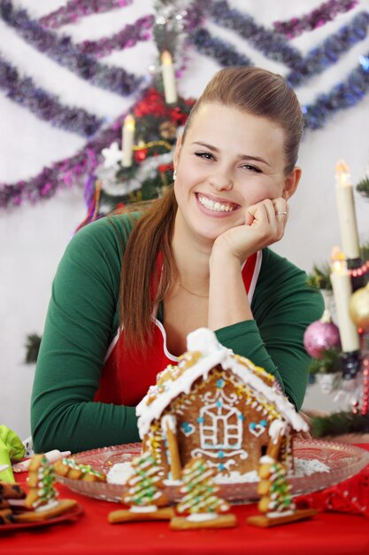 Belle jeune femme décorée de maison en pain d'épice