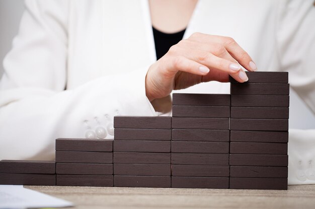 Belle jeune femme démontre sur le concept de développement des affaires de barres en bois