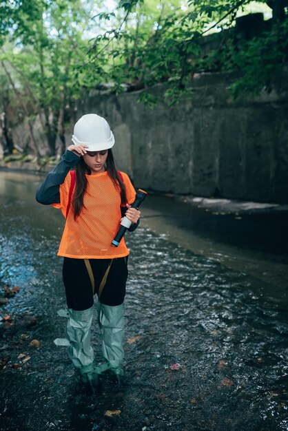 Belle jeune femme digger se promène le long du collecteur de pluie