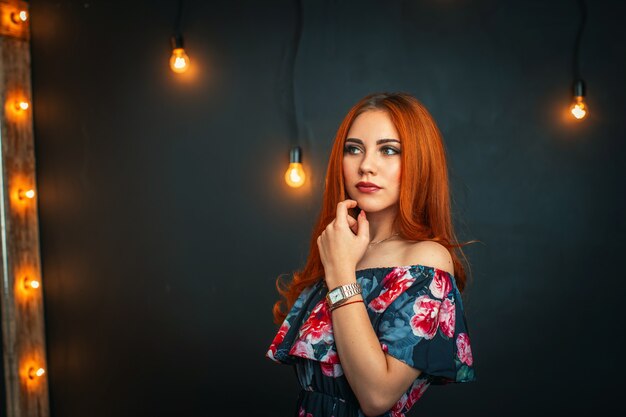 Belle jeune femme avec du maquillage de soirée et une robe ouverte regarde ailleurs