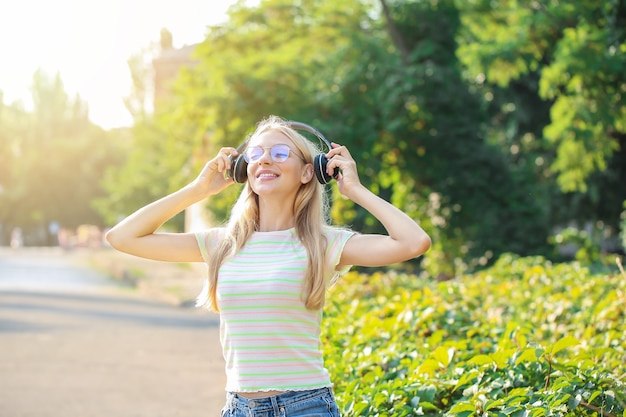 Belle jeune femme écoutant de la musique en plein air