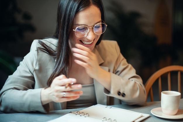 Belle jeune femme écrivant ses plans d'affaires sur le journal