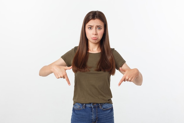 Belle jeune femme élégante sur fond isolé, pointant la main et les doigts avec une expression triste.