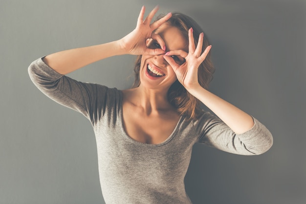 Belle jeune femme élégante montre des lunettes.