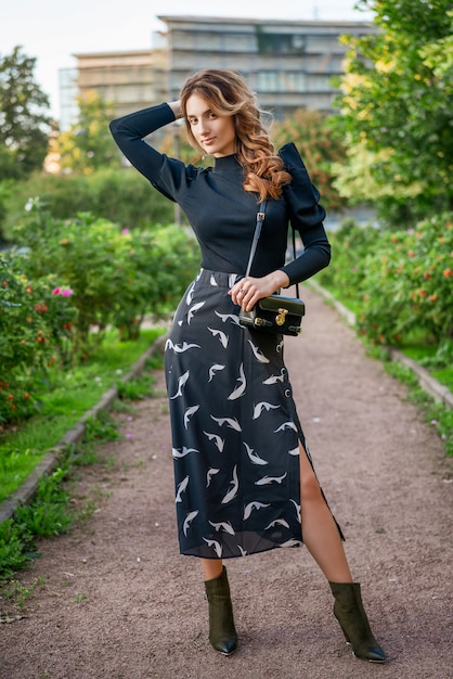 Belle jeune femme élégante posant à l'extérieur sur une journée de printemps ensoleillée