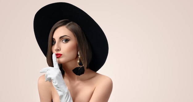 Belle jeune femme élégante qui pose en studio sur fond beige