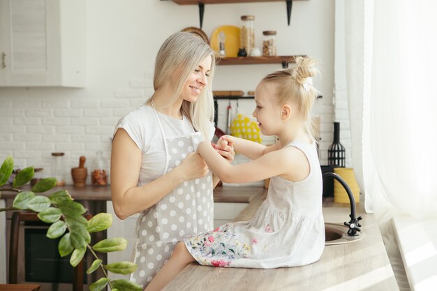 Belle jeune femme embrasse et embrasse sa petite fille mignonne. Tonifiant.