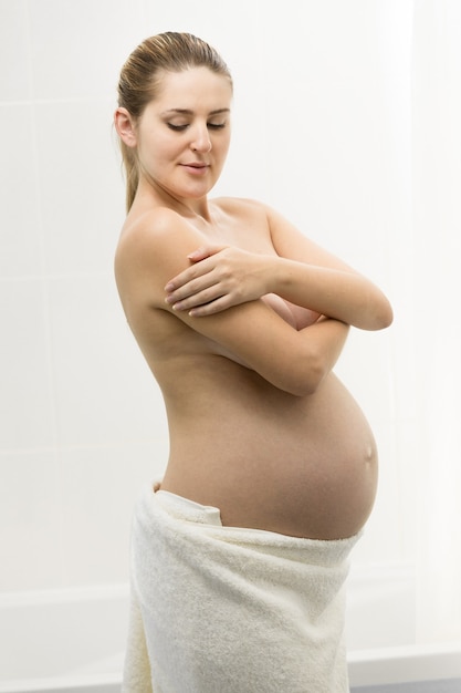 Belle jeune femme enceinte ayant posant dans la salle de bain