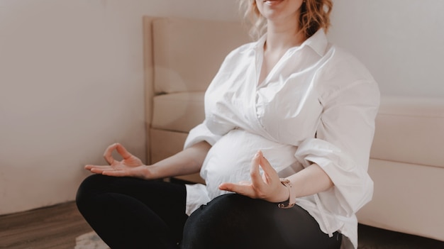 Belle jeune femme enceinte fait du yoga à la maison. Pose de détente, se calmer, se détendre.