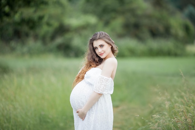 Une belle jeune femme enceinte posant