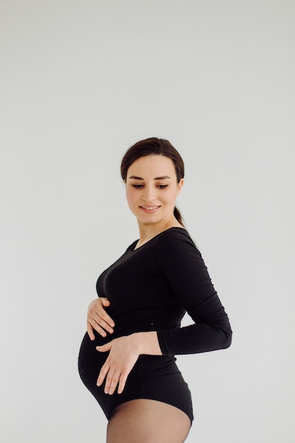 Belle jeune femme enceinte qui pose en studio en robe