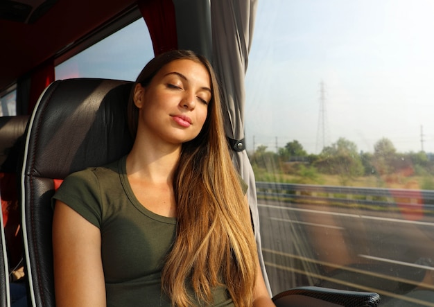 Belle jeune femme endormie assise dans le bus. Passager de bus voyageant assis sur un siège et dormant.