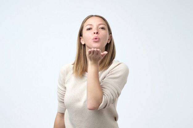 Belle jeune femme envoyant un baiser d'air