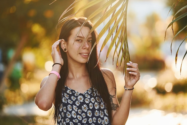 Belle jeune femme est à l'extérieur pendant la journée ensoleillée Concept de vacances