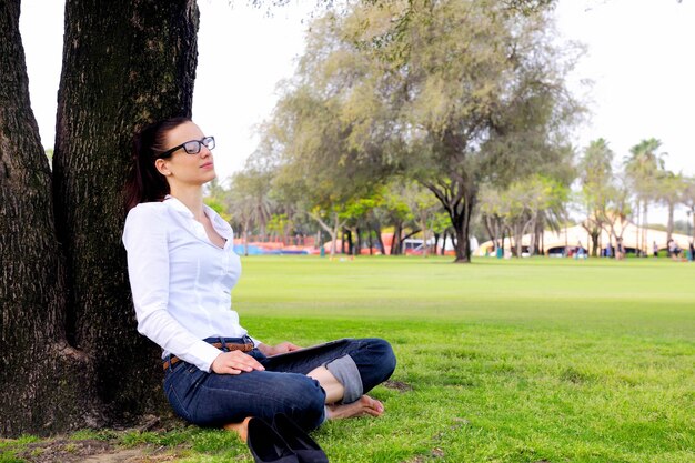 Belle jeune femme étudiante étudie avec tablette dans le parc