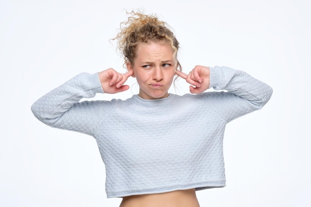 Photo belle jeune femme européenne bouclée branchant les oreilles regardant de côté