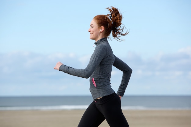 Belle jeune femme exerçant par la plage