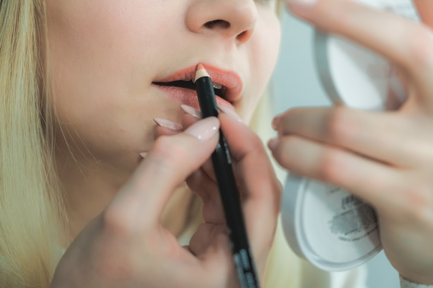 Belle jeune femme faisant du maquillage