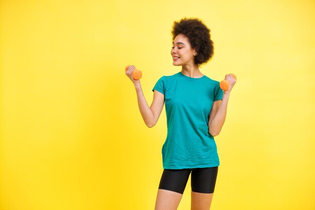 belle jeune femme faisant du sport au gymnase. modèle féminin posant pour un concept de corps positif et d'acceptation de soi photoshooting sur fond coloré