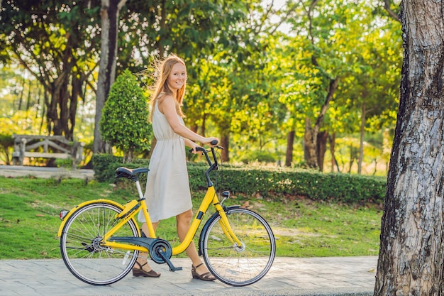 Belle jeune femme faisant du vélo dans un parc. Les gens actifs. Extérieur