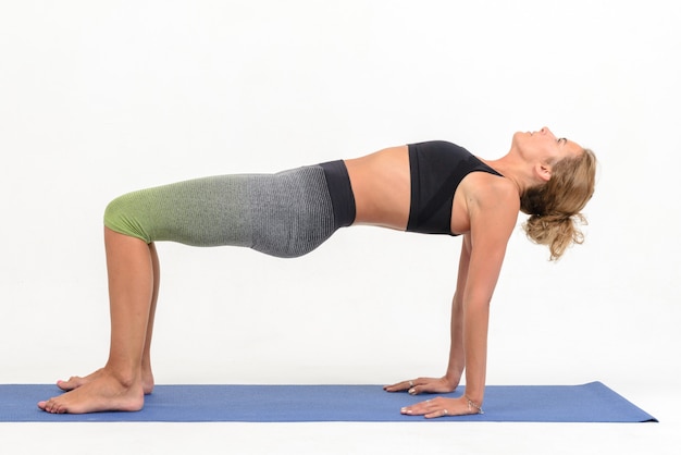 Belle jeune femme faisant du yoga sur blanc