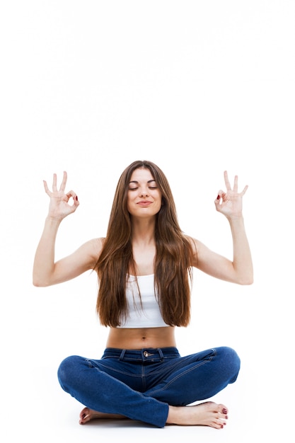 Belle jeune femme faisant du yoga sur fond blanc.