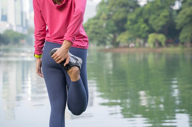 Belle jeune femme faisant de l'exercice dans le parcModèle de fitness féminin asiatique travaillant le matin