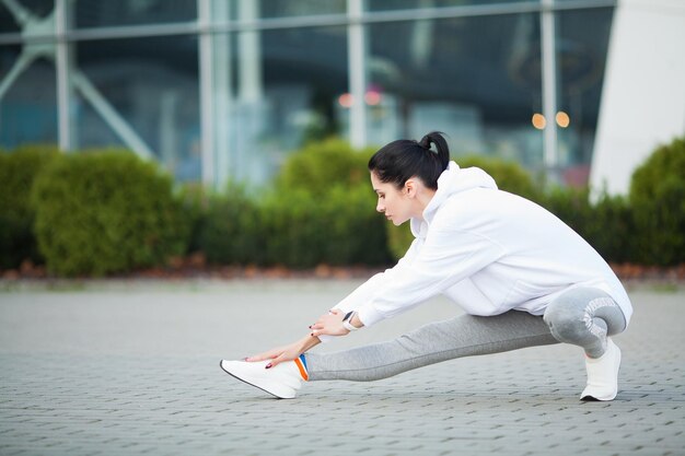 Belle jeune femme faisant des exercices dans le parc