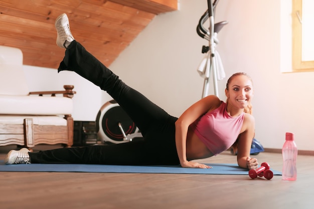 Belle jeune femme faisant des exercices à la maison.