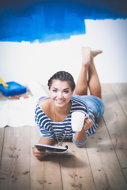 Belle jeune femme faisant de la peinture murale debout sur une échelle belle jeune femme