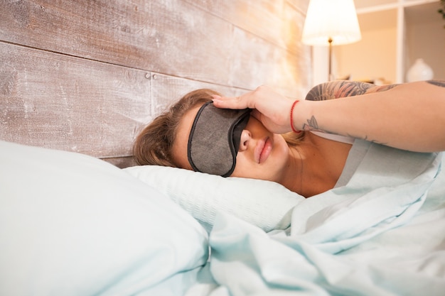 Belle jeune femme faisant une sieste avec ses masques pour les yeux.