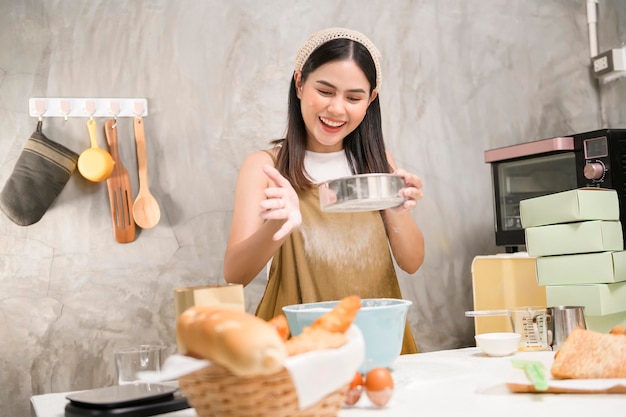 Belle jeune femme fait cuire dans sa cuisine boulangerie et café-restaurant