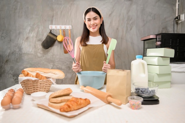 Belle jeune femme fait cuire dans sa cuisine boulangerie et café-restaurant