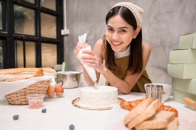 Belle jeune femme fait cuire dans sa cuisine boulangerie et café-restaurant