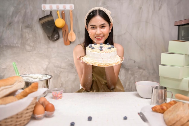 Belle jeune femme fait cuire dans sa cuisine boulangerie et café-restaurant