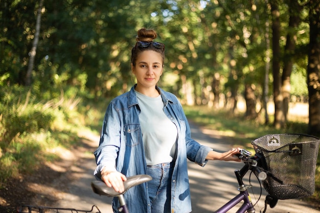 Belle jeune femme fait du vélo dans le parc