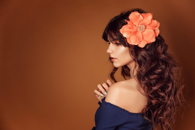 Belle jeune femme avec des fleurs dans les cheveux et le maquillage, photo tonique