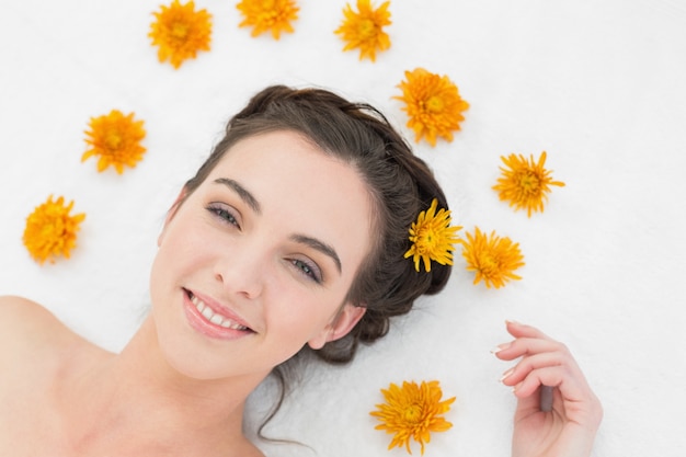 Belle jeune femme avec des fleurs dans un salon de beauté