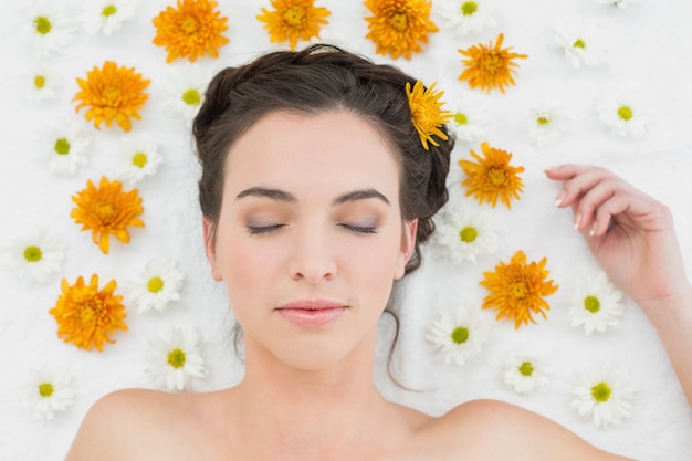 Belle jeune femme avec des fleurs dans un salon de beauté