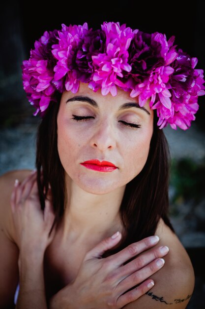 Belle jeune femme avec des fleurs roses dans les cheveux