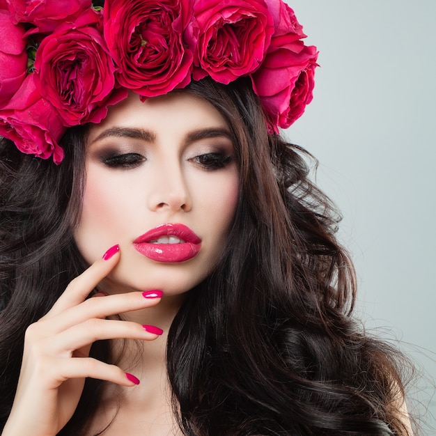 Belle jeune femme avec des fleurs roses