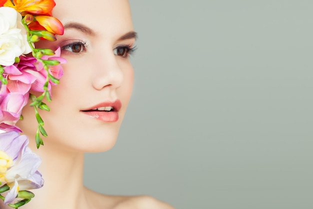 Belle jeune femme avec des fleurs vives Spa beauté aromathérapie et concept de soins de la peau