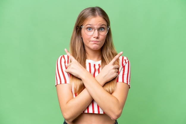 Belle jeune femme sur fond isolé pointant vers les latéraux ayant des doutes