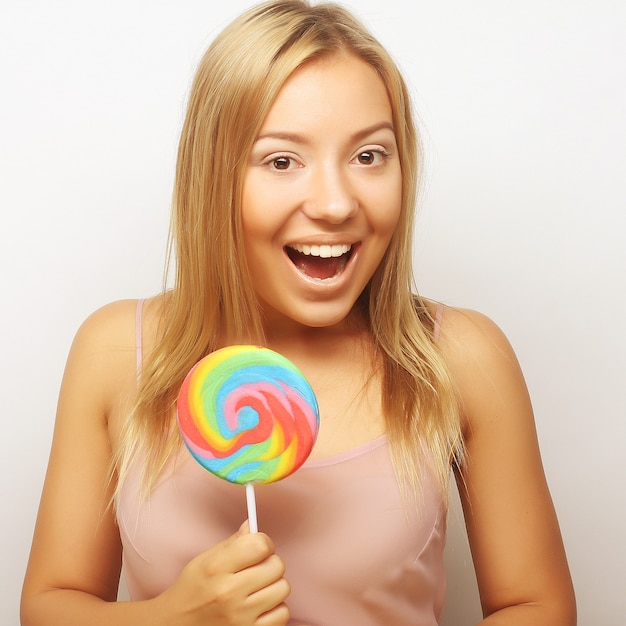 Belle jeune femme avec une grosse sucette colorée